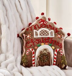 a decorative gingerbread house pillow on a couch