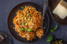 two black plates filled with pasta and vegetables