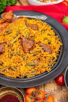 a plate full of rice and vegetables on a table with other food items around it