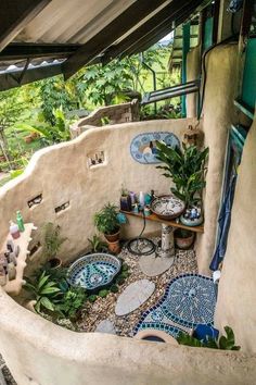 an outdoor area with blue and white tiles on the walls, potted plants and other decorative items