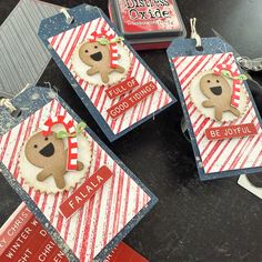 three tags decorated with christmas themed items on top of a table next to some scissors