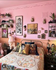 a bedroom with pink walls and pictures on the wall