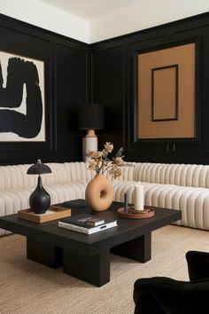 a black and white living room with couches, coffee table and art on the wall