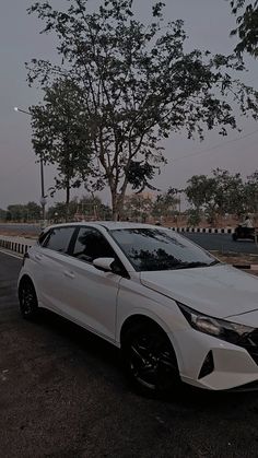 a white car is parked on the side of the road