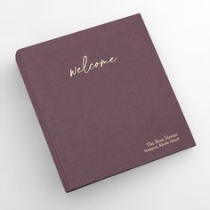 a purple book with the word welcome written in gold on it's front cover