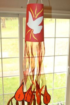 a wind chime hanging in front of a window with red shoes on the table