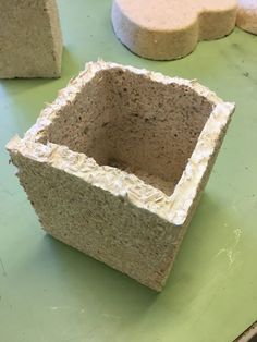 some kind of container sitting on top of a green table next to two smaller ones