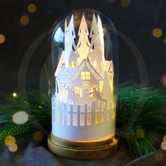 a lighted snow globe with a house in it