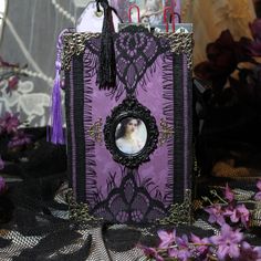 a purple book with a cat in the center and a black lace border around it