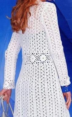 a woman with red hair wearing a white crochet dress and carrying a handbag