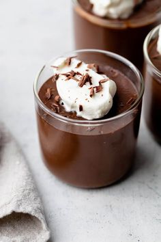 three glasses filled with chocolate pudding and whipped cream