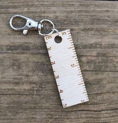 "Do you ever need a little wee ruler to measure something? This little bitty ruler is 2\" long and has a metal clasp so you can clip it pretty much anywhere. I keep one on my key ring just in case.  It measures 2\" (3cm) long and 0.75\" (2cm) wide. One side is metric and the other is in inches. I laser cut and engraved these from 1/8\" (3mm) birch. It has been lightly sanded." Wooden Ruler, Crochet Tools, Knitting Tools, Lipstick Holder, Dk Yarn, Sock Yarn, Key Chains, Tool Set, Key Rings