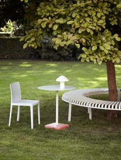 two white chairs and a table in the grass