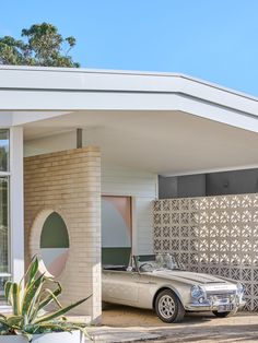 a car is parked in front of a house with a circular design on the wall