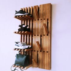 there is a shoe rack on the wall with two pairs of shoes hanging from it