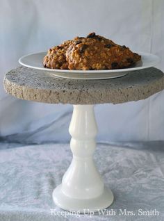 a white plate topped with cookies on top of a cake stand