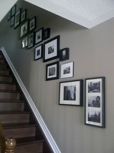 the stairs are lined with black and white framed pictures on the wall above them is a staircase