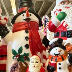 a group of snowmen and santa clause figurines on display in a store