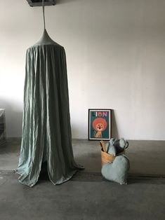 a room with a large drape on the ceiling and two stuffed animals sitting in front of it