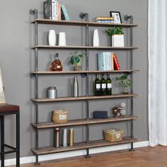 an industrial style shelving unit in a living room with grey walls and wooden floors