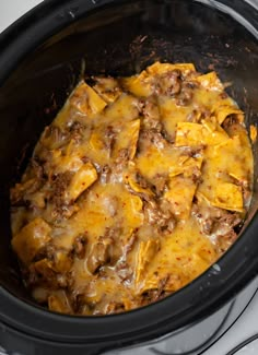 a crock pot filled with cheese and ground beef