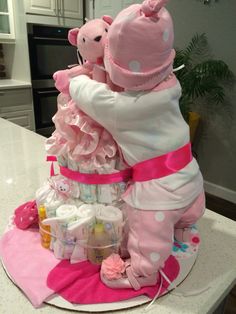 a large pink teddy bear sitting on top of a pile of diapers