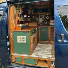 an open van door showing the kitchen and bar in it's cargo area,