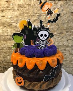 a halloween cake decorated with chocolate frosting, sprinkles and pumpkin decorations