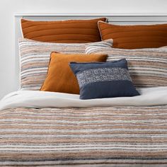 a bed with orange and blue pillows on it