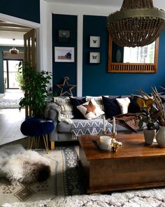 a living room filled with furniture and a wooden coffee table in front of a blue wall