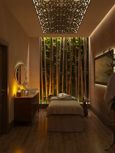 a spa room with bamboo trees in the background and lights on either side of the bed