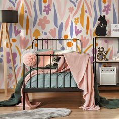 a child's bedroom with colorful wallpaper and bedding, including a cat