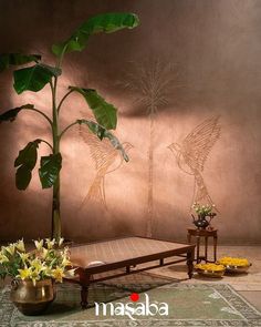 a living room with a large plant in the center and two vases filled with flowers next to it