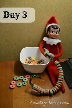 an elf is sitting next to a bowl of cereal and doughnuts on the table