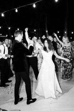 the bride and groom are dancing together at their wedding reception in front of an audience