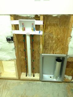 an air conditioner and water heater installed in a room under construction with plywood on the walls