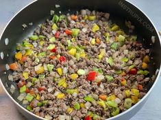 a pan filled with meat and vegetables on top of a table