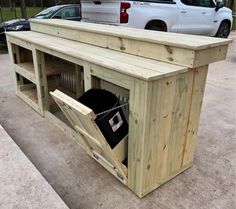 a large wooden bench sitting on top of a cement floor next to a white truck