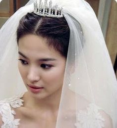 a woman wearing a wedding veil with a tiara on her head