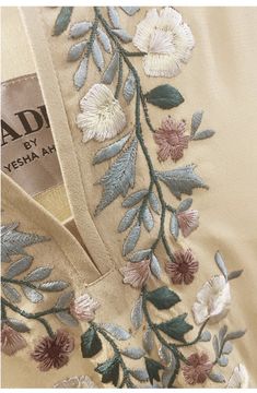 an embroidered dress with flowers and leaves on the front, along with a label that says dead