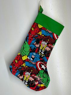 a christmas stocking hanging on the wall with comic characters all over it's surface