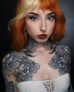 a woman with red hair and tattoos on her chest is shown in the instagramture