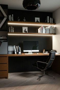 a desk with a computer on top of it in front of a bookshelf