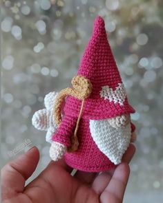 a small crocheted pink and white gnome doll