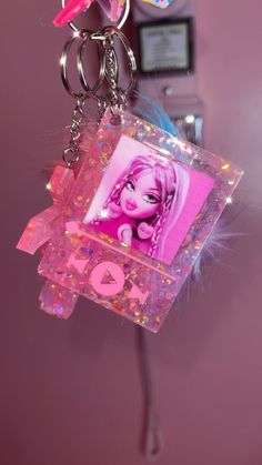 a pink keychain with an image of a barbie doll on it's front