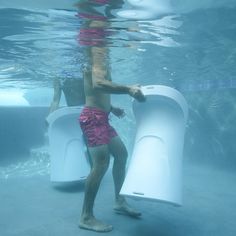 a man standing in the water next to an object