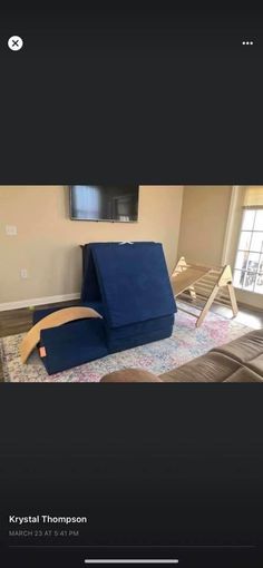 a blue couch sitting in the middle of a living room next to a tv monitor