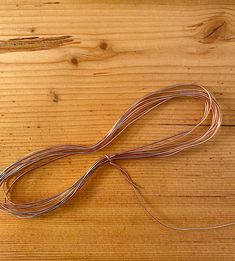 a piece of wire sitting on top of a wooden table