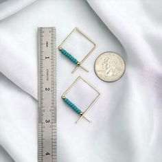 Elevate your style with True - Square Gold & Turquoise! These stunning square threader earrings feature 14k Gold Filled wire and vibrant teal turquoise seed beads, perfect for adding a touch of elegance to any outfit. Embrace your bold and sophisticated side with these unique and eye-catching earrings. 14k Gold Filled Wire Sides of square measure 3/4" Teal Turquoise Miyuki Seed Beads Polished to a High Shine Sent in a Ribboned Gift Box with Polishing Cloth Handmade in Montana Adjustable Square Turquoise Jewelry, Handmade Square Turquoise Jewelry, African Turquoise, Teal Turquoise, Threader Earrings, Jewelry Packaging, Christmas Shopping, Montana, Seed Beads