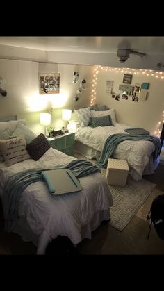 two beds in a room with lights on the wall and pictures on the wall above them